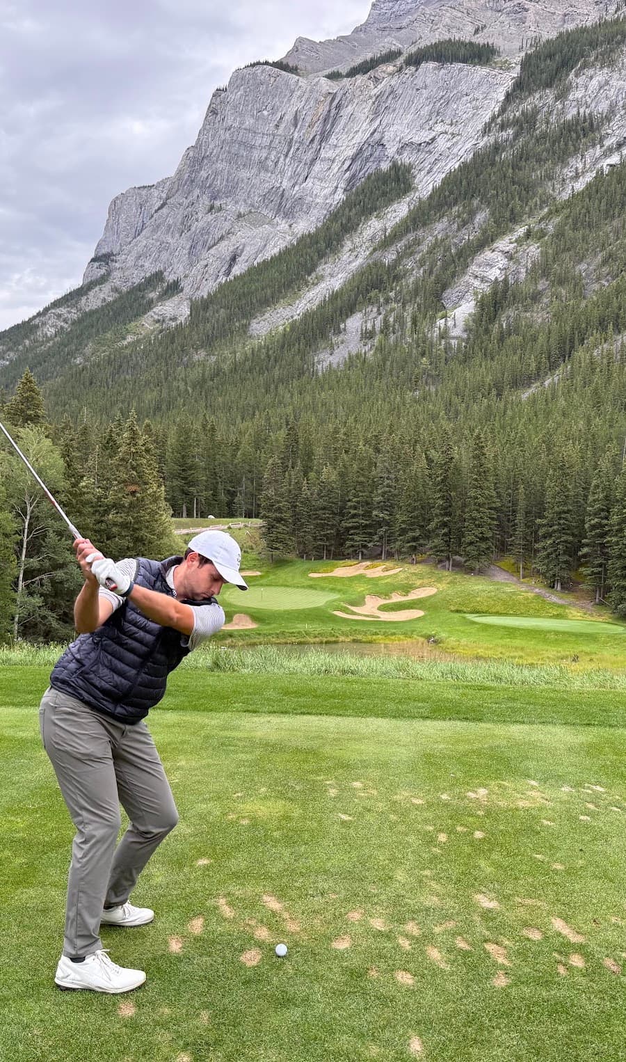 Zach teeing off with mountains in the background
